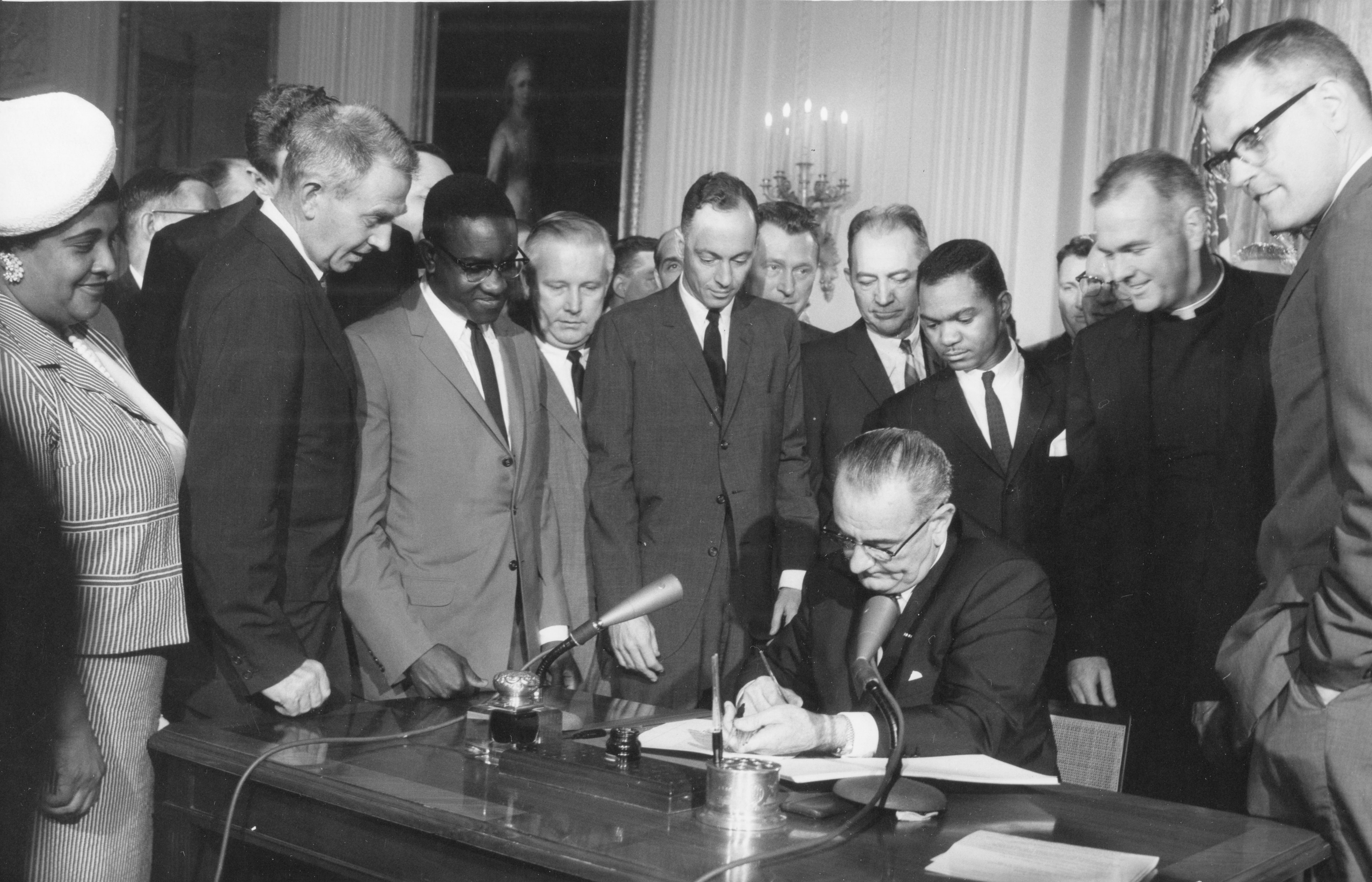 President Lyndon Johnson signs the Civil Rights Act of 1964.